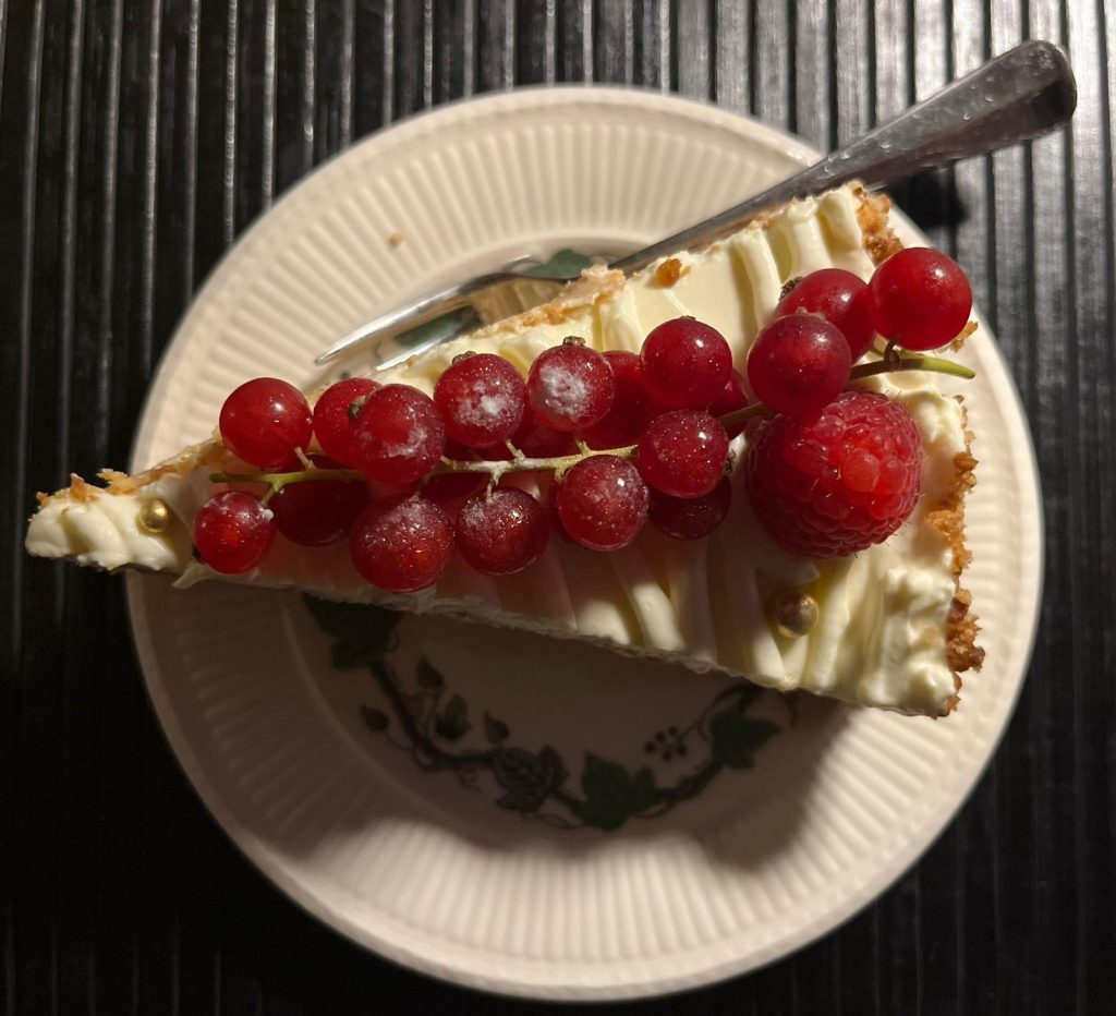 gebaksbordje met een stukje taart en rode besjes