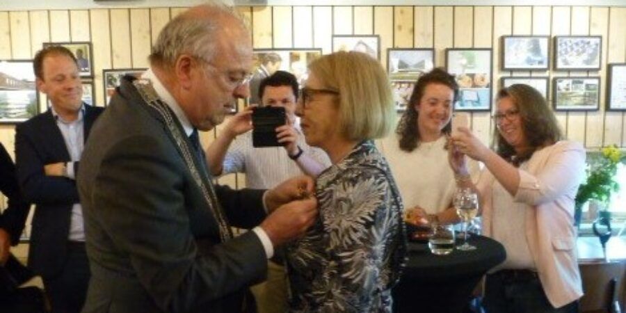 Burgemeester Peter van der Velden spelt de versierselen op